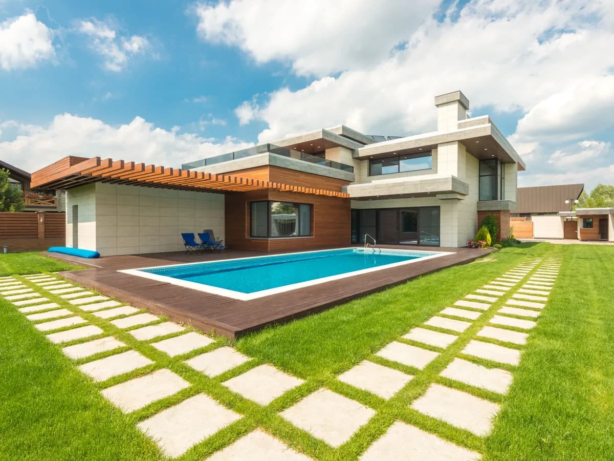Modern home backyard with geometric pool, wood deck, and clean equipment-ready patio