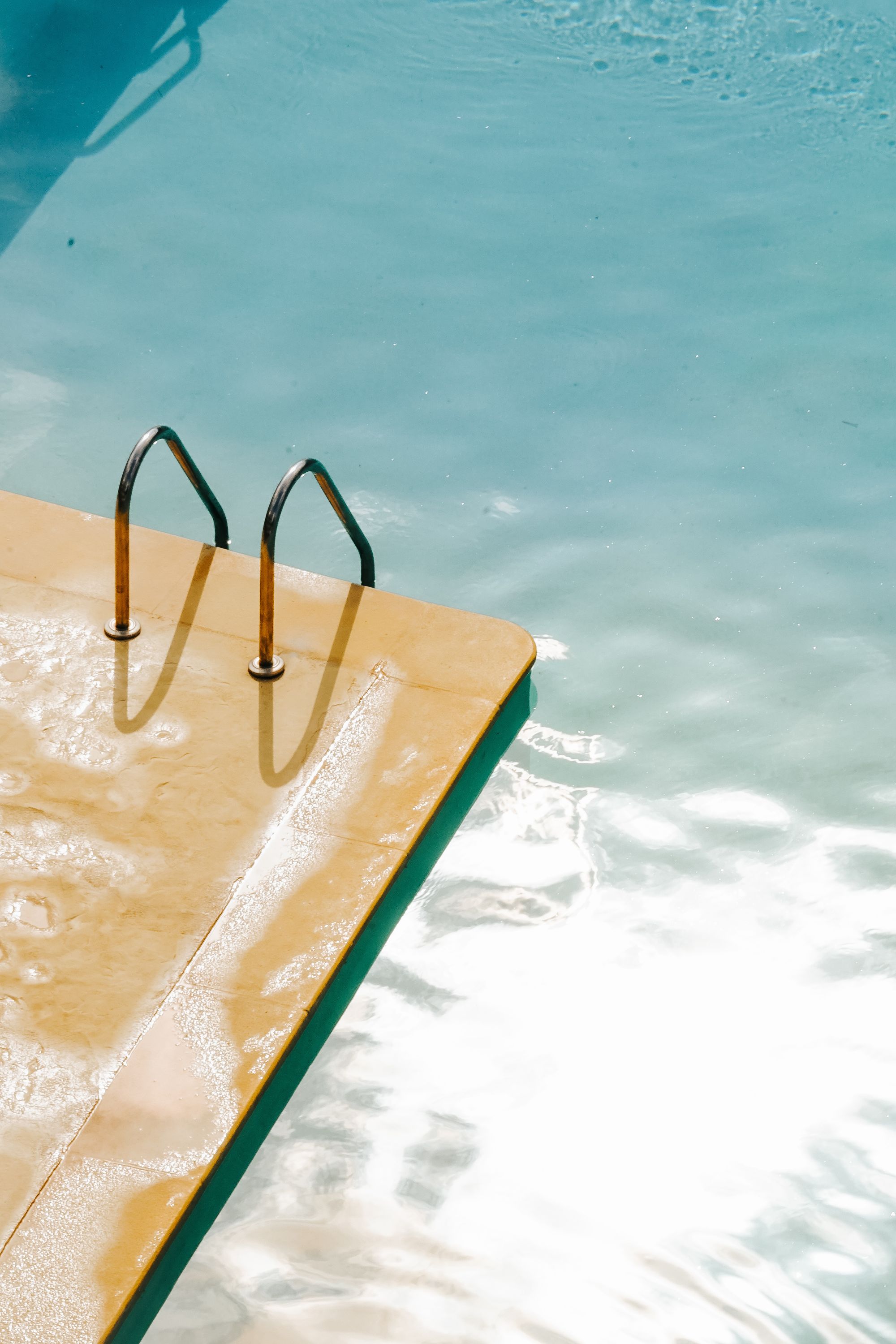 Sparkling blue residential pool water with sunlight reflections